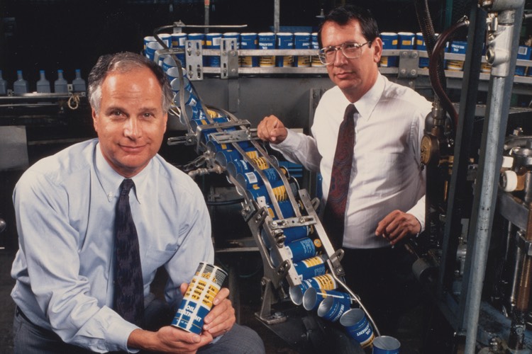 Bob Hirsch and Rich Hirsch standing near a production line
