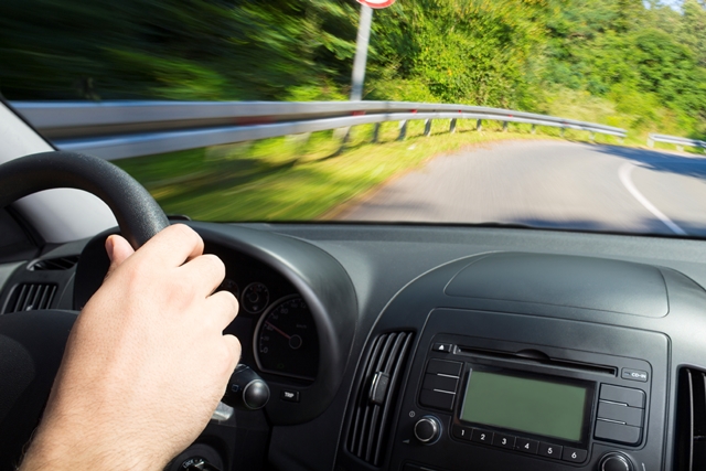 person's hand on the steering wheel of a car