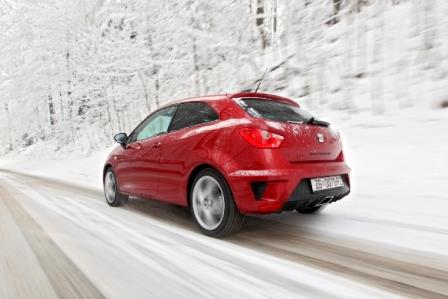 red car driving on snowy road