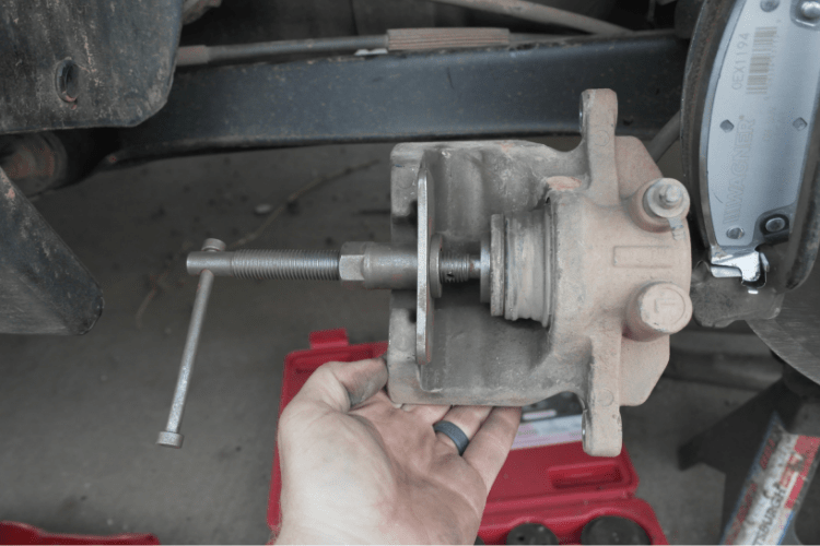 The tool installs like this into the caliper. Then you just crank the handle until the piston is fully retracted. Make sure the boot does not pooch out. If it does, carefully roll it back into place.