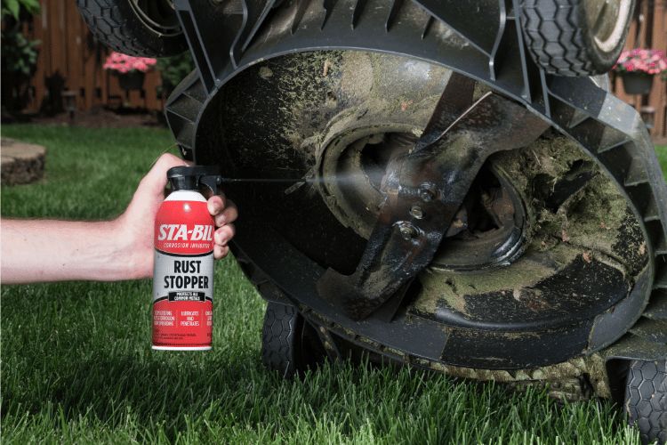 aerosol can spraying a lawnmower's undercarriage