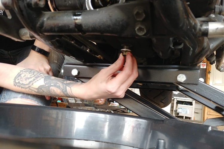 Insert oil pan drain bolt by hand.