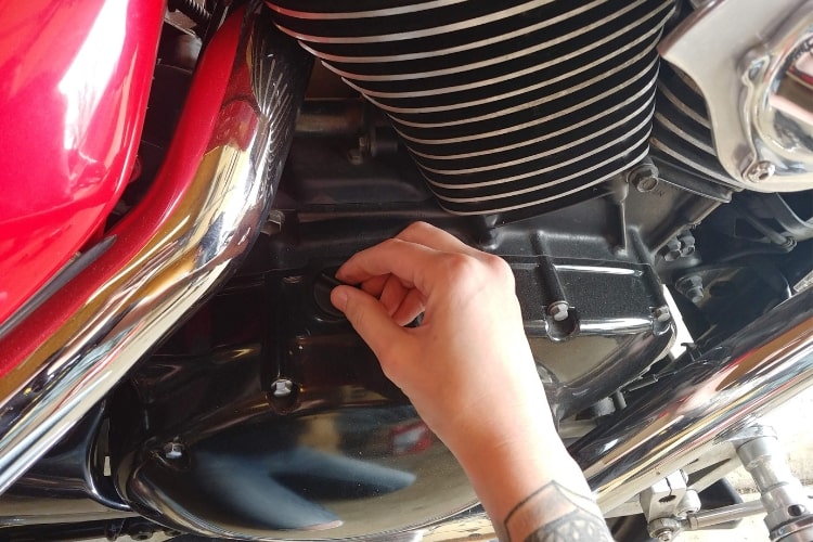 Removing the oil cap will help the motorcycle oil drain more efficiently.