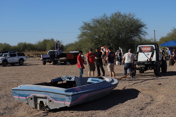 people standing close to abandoned boat in desert