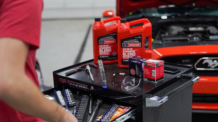 work bench with bottles of motor oil, tools, and Ford Mustang in the background