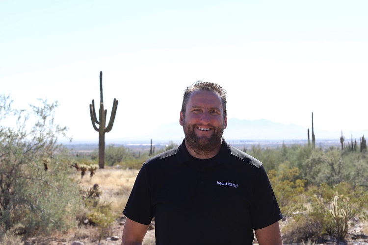 person smiling directly at camera in a desert landscape
