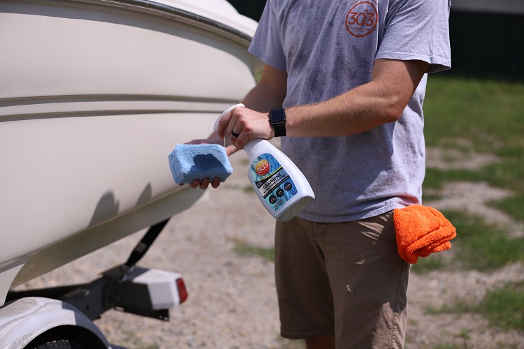 person spraying 303 Marine Graphene Nano Spray Coating on blue applicator