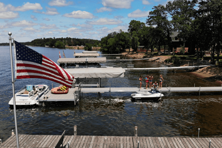 American Flag Looking Down Docks Girls On Dock min