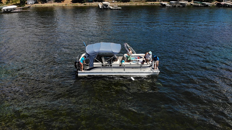 five people spread out on a pontoon boat
