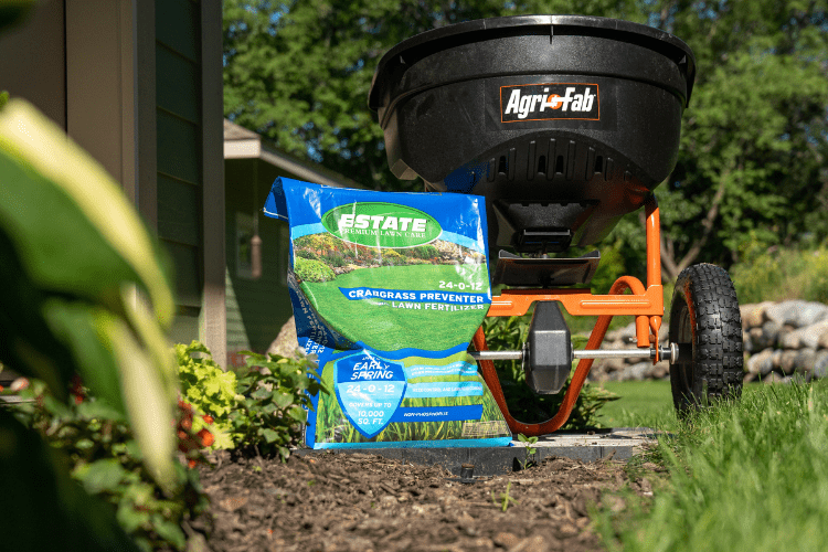 bag of crabgrass control in front of spreader tool