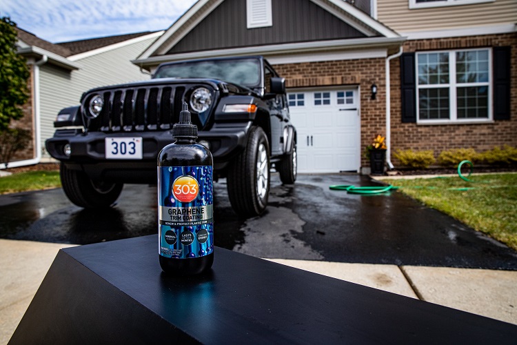 bottle of 303 Graphene Trim Coating with Jeep Wrangler in background of driveway