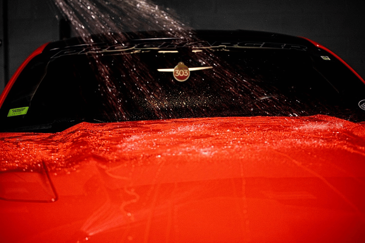 water pouring on top of a car hood